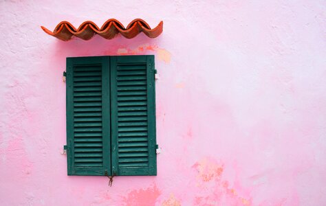 Closed Green Window Shutters on Grunge Pink Wall Background photo
