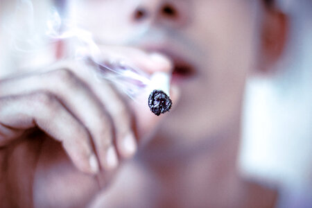 Young Man Smoking Cigarette, Closeup photo
