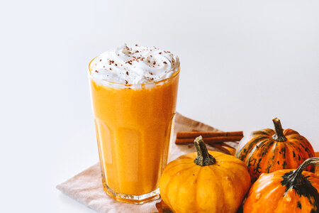 2 Pumpkin smoothie. Small pumpkins and drink on the white background photo