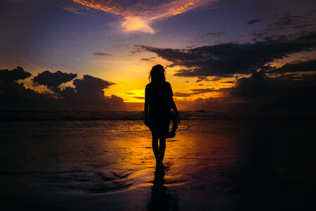 Woman Walking on the Beach at Sunset photo