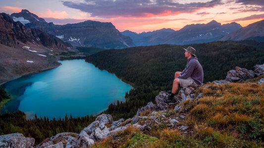 Man Sitting and overlooking the beautiful lake landscape at Banff National Park, Alberta, Canada photo