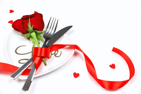 2 Fork, knife and spoon with red rose on white table. Love concept