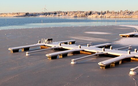 View of snow covered piers on frozen lake photo