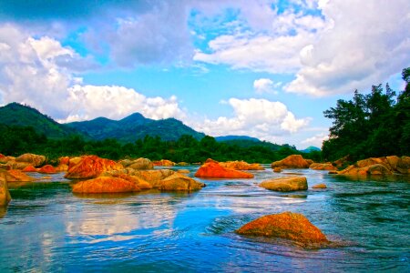 landscape with mountains trees and a river in front