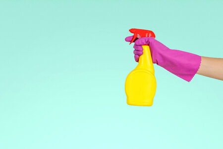 1 Hand in gloves holds spray bottle. photo