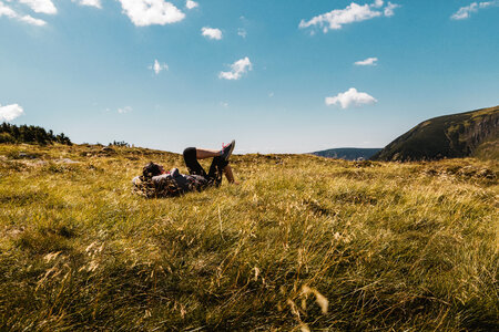 2 Carefree happy woman lying on green grass meadow on top of mountain photo