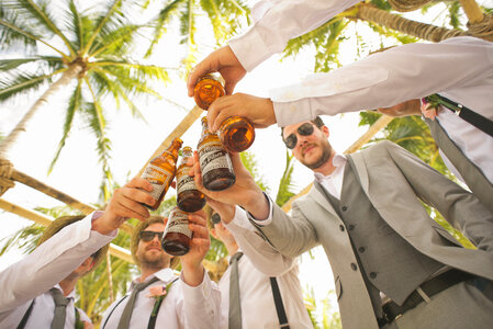 Men Drinking Beer under the Palmtrees During the Wedding Party photo