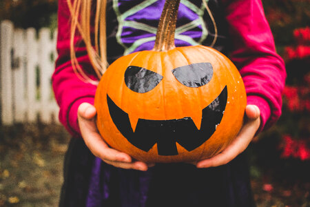 Girl holding Jack-O-Lantern Halloween Pumpkin scary face photo
