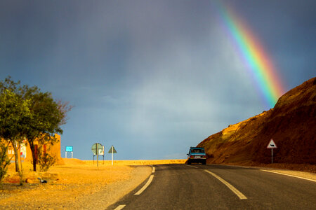 Car Driving into the landscape with a rainbow