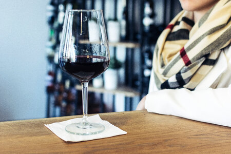 Lady drinking her glass of red wine in a wine shop photo