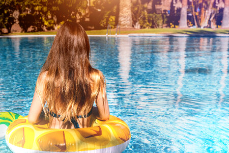Girl in bikini enjoying summer sun and tanning during holidays in pool