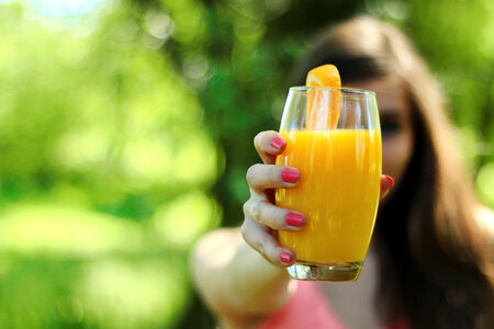 Girl in the background holding a glass of orange juice photo
