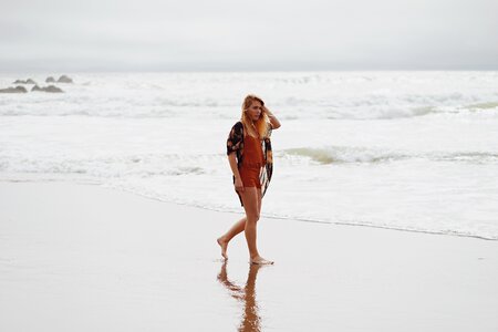 Blond Woman Walking Alone Along a Beach photo