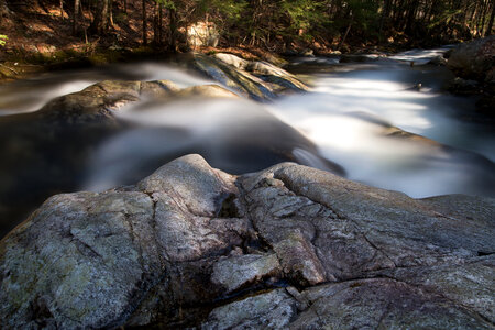Rapidly flowing water cascading down rocks photo