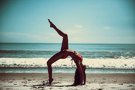 Attractive Woman in Bikini Doing Yoga at the Sea photo
