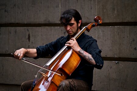Man with Tattoo Playing Cello Outdoors photo