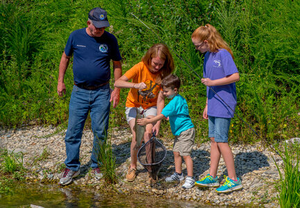 Family fishing, mother nets rainbow trout-1