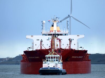 Tugboat assisting cargo ship to harbor photo