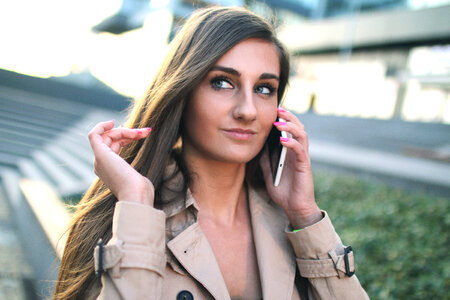 Portrait of a sympathetic young lady on the phone on the street photo