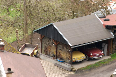Two old czeach cars in carport photo