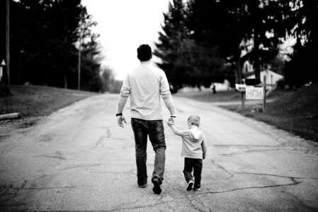 Father and Little Boy Walking Down the Street photo