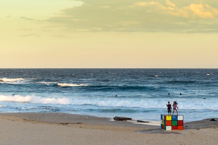 Kids standing on Rubik cube at maroubra beach, Australia photo