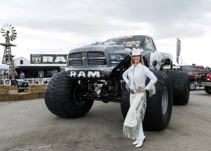 Cowgirl dressed in white standing next to monster truck in Texas photo