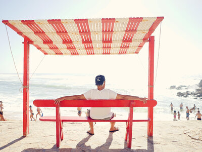 Man in Cap and Flip-Flops Looking at the Beach photo