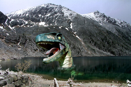 Dinosaur coming out of the lake with mountain in the background photo
