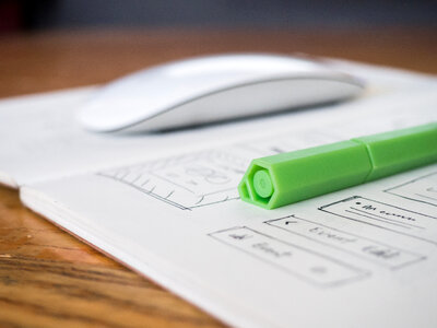 Green Pen and Sketchbook on Desk photo