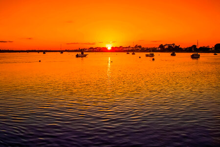 Sunset over the waters with boats at Christchurch, England photo