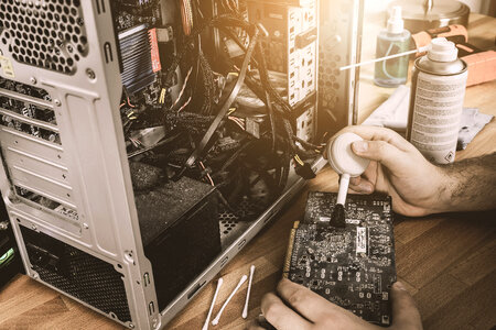 Cleaning a graphic card fan with a brush. Cleaning PC concept photo