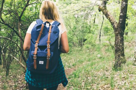 Blond Girl with a Backpack Exploring a Forest photo