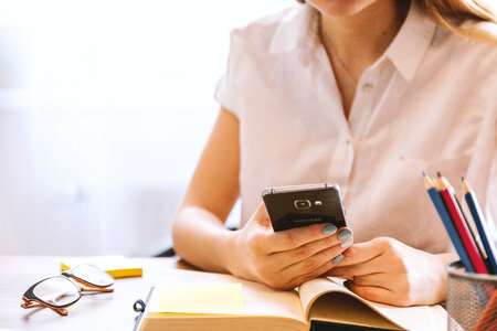 Young woman uses smartphone at the office photo