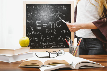 1 Teacher teaching and writes mathematical equations on the blackboard. Education and School concept. photo