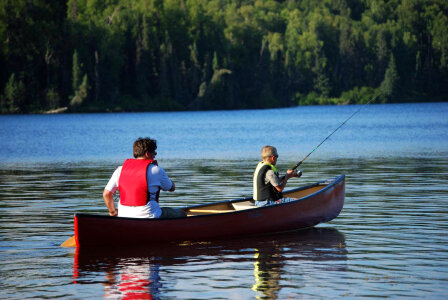 Fishing from canoe on lake photo