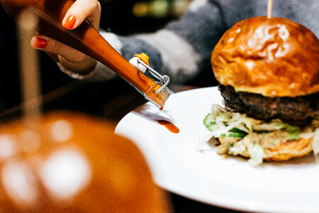 Girl pouring a spicy sauce photo