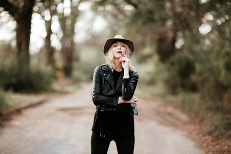 Fashion Blonde Woman Posing Outdoor in Black Hat and Leather Jacket photo