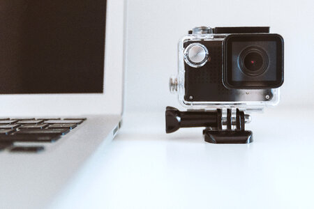 Close up of MacBook and camera GoPro on white Background photo