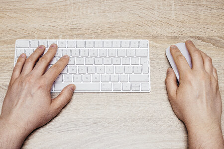 Man Typing on White Keyboard photo