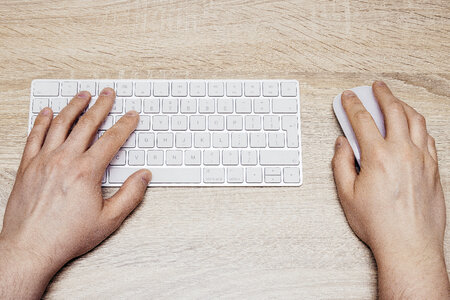 Man Typing on White Keyboard