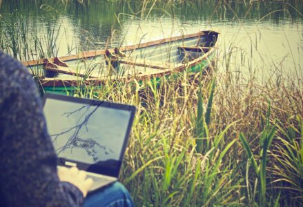 Man on Laptop with Boat Free Photo