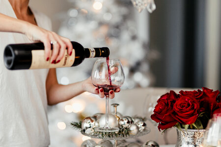 Woman pouring red wine in a glass photo