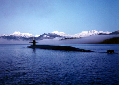 Submarine surfacing with mountains in the landscape photo