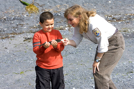Service employee talking with a child about the fish he is holding
