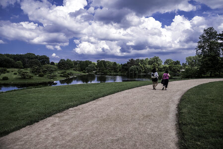 People walking on the path under the clouds landscape photo