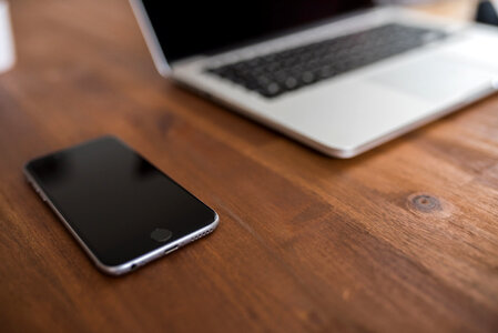 iPhone & Macbook Computer on Wood Desk photo