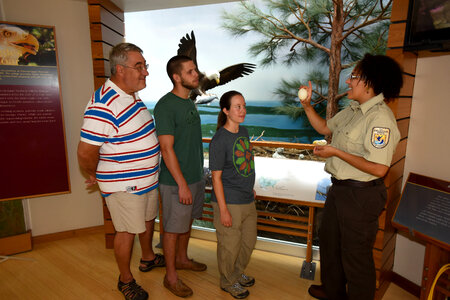 FWS Staff shows visitors an eagle egg photo
