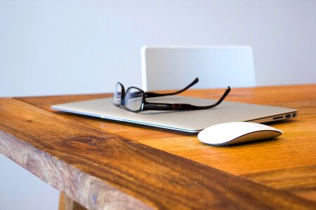 Laptop and glassese on wooden table photo