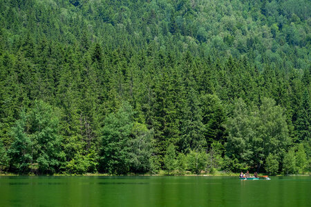 Boat on a Volcanic Green Lake Surrounded of a Forest photo